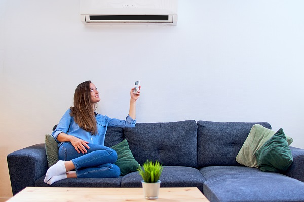 Mantenere costante temperatura casa senza sprechi energetici Donna regola la temperatura del condizionatore.